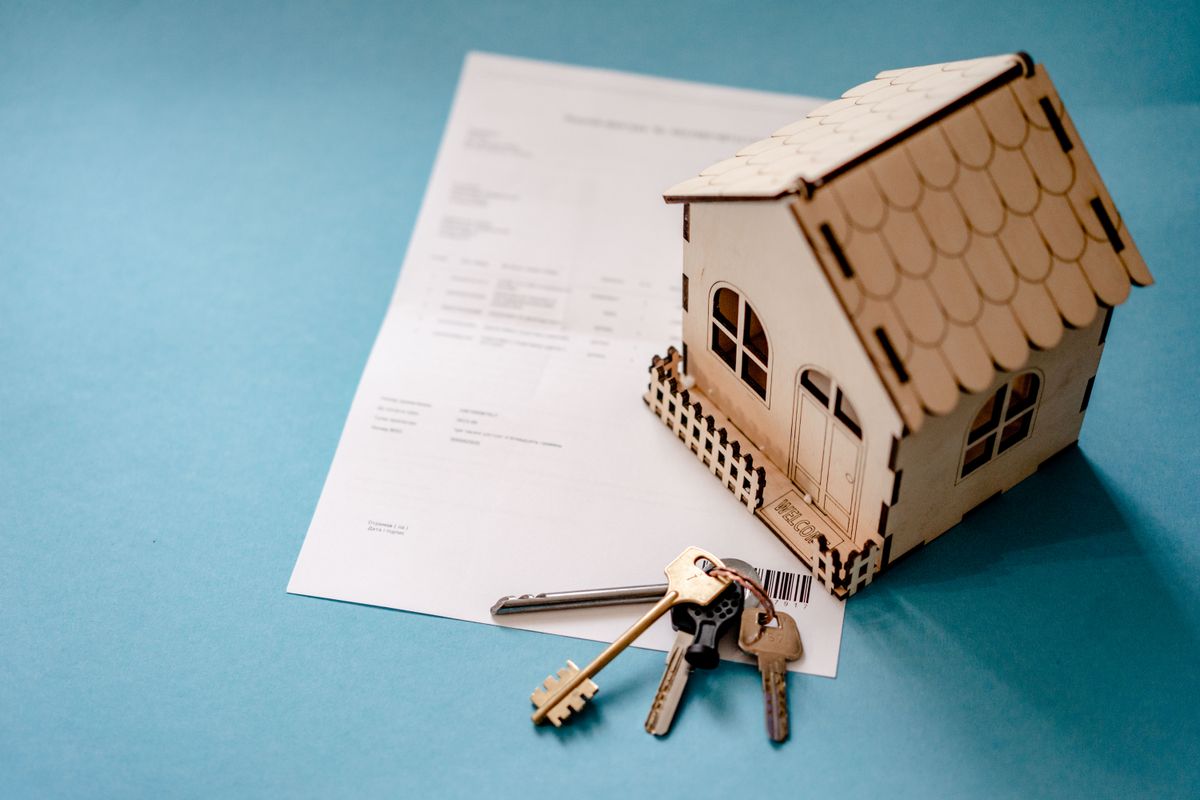 A model house and keys on paperwork